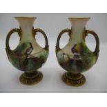 A pair of small early 20th century Royal Worcester vases of bulbous form with twin handles, on a