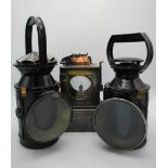 Two black painted railway lamps with rotating handles, blue and red lenses, 11" h and 13"h and an