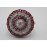 A platinum flower design ring set with bands of diamonds and calibre cut rubies