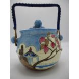 A Clarice Cliff Blue Japan pattern biscuit barrel with a ball finial to the lid and wicker swing