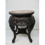 A late 19th century Chinese rosewood stand with a mottled marble top and bead edge, over a flower