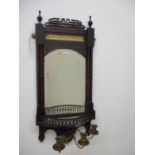 An Edwardian mahogany girandole with a fretworked cornice, turned pillars, brass panel and