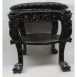 A late 19th century Chinese hardwood stand with a lobed, inset mottled marble top, carved border and