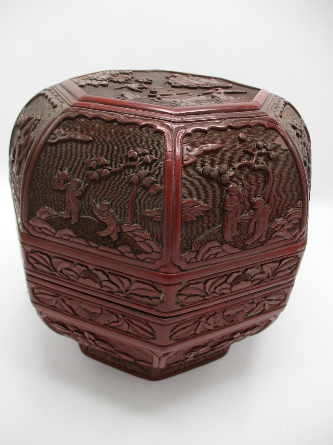 A large 19th century Chinese cinnabar box of octagonal form, the domed lid decorated with panels
