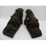 A pair of 20th century Chinese carved wooden foo dogs with a ball, on a stepped base, 7" h, 9"w