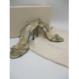 A pair of boxed Jimmy Choo gold glitter strappy high heeled shoes, size 38, A/F. Dust bag
