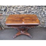 A William IV rosewood card table with a rotating foldover top, over an octagonal vase shaped
