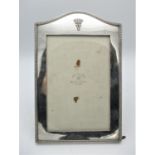 A George V silver photograph frame by Mappin & Webb, London 1923, with arched top, patterned