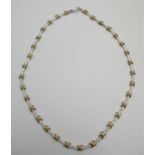 A Chaumet style 18ct white and yellow gold necklace with crossover and baton links sixteen of