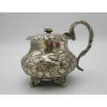 A George IV silver mustard pot by Joseph Biggs, London 1825, of bulbous form with embossed foliage