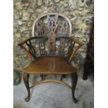 A late 19th/early 20th century Gothic style ash and elm low back Windsor armchair, with pierced back