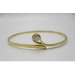 An 18ct yellow gold bangle with a crossover loop set with a diamond approximately 0.25ct, maker