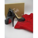 A pair of boxed Christian Louboutin black patent leather open toe stiletto with iconic red