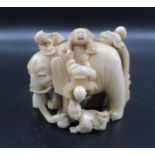 A Japanese Meiji period ivory netsuke, modelled as six blind men and an elephant, as an allegory