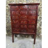 A 20th century Chinese apothecary chest on legs, comprising eight drawers with hoop handles and