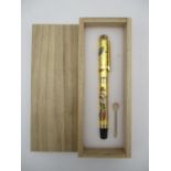 A Japanese Maki-e style fountain pen, the lacquer design depicting a geisha with fans and cherry