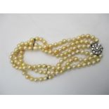 A three strand pearl necklace with a silver clasp set with white sapphires, boxed