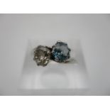 A platinum diamond ring set with a vivid blue diamond, 0.74cts and the other a round cut diamond 0.