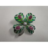A silver and enamelled brooch fashioned as a four leaf clover, set with rubies, a pearl and