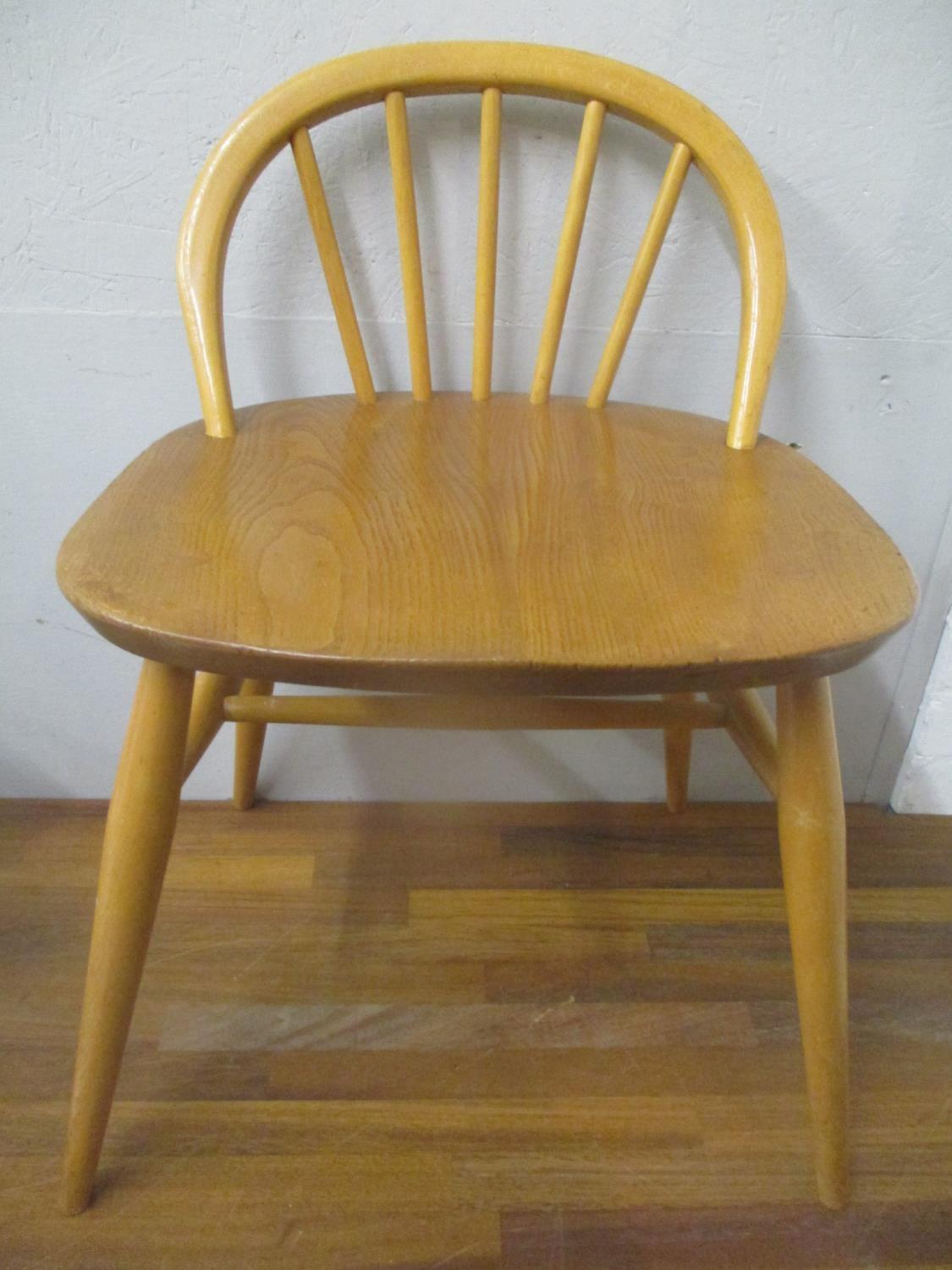 An Ercol beech and elm dressing table chair with a low hoop back, on turned legs