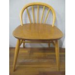 An Ercol beech and elm dressing table chair with a low hoop back, on turned legs