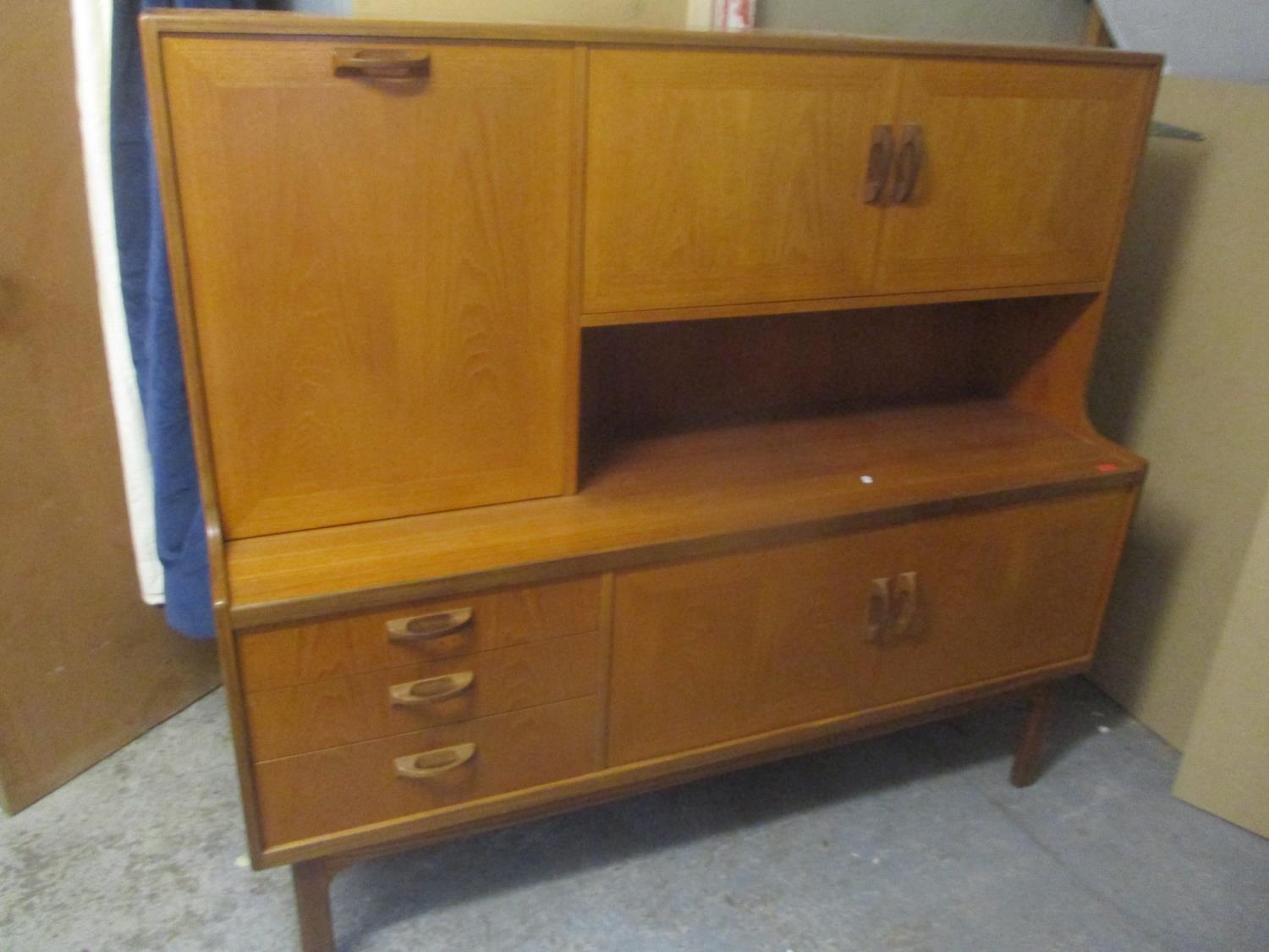 A 1970's E Gomme G Plan Fresco highboard having twin cupboard doors and pull down with internal