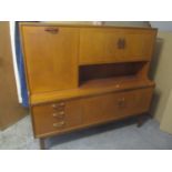 A 1970's E Gomme G Plan Fresco highboard having twin cupboard doors and pull down with internal