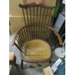 An early 20th century Windsor combe spindle back armchair with rattan seat