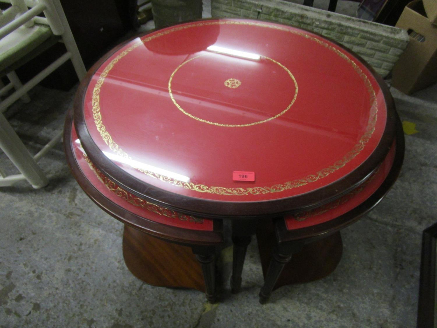 A modern mahogany nesting set of five occasional tables with red faux leather top