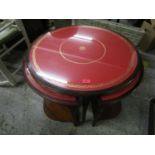 A modern mahogany nesting set of five occasional tables with red faux leather top