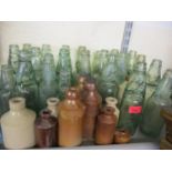 A collection of Victorian glass and pottery bottles to include 22 Codd bottles, 10 ginger beer