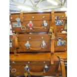 A graduated set of three leather suitcases with chrome locks and studs 68"w - 48"w