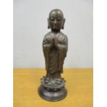 An Oriental patinated bronze figure of Buddah, raised on a lotus base, 23.5cm h