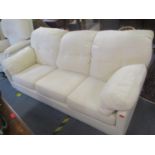 A modern cream upholstered three seater sofa