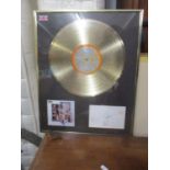 A gold presentation disc for the Oasis album 'Stop the Clocks' framed with cut signatures of all