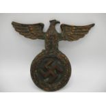 A WWII German Third Reich iron NSDAP wall plaque with an eagle perched on a wreath, 7 1/2"h