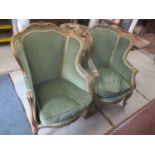 A pair of late 19th century French gilt wood armchairs having applied floral moulding and on short