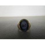 An Elizabeth II 9ct yellow gold gents signet ring, with inset stone intaglio, engraved with a family