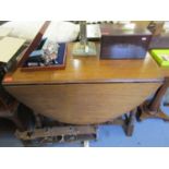 A 1930's oak drop leaf dining table reproduction and stained beech framed wing back chair