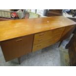 A mid 20th century Retro teak sideboard having three drawers flanked by two cupboard doors 72.5cm