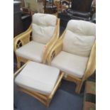 A pair of conservatory wicker armchairs and a foot stool