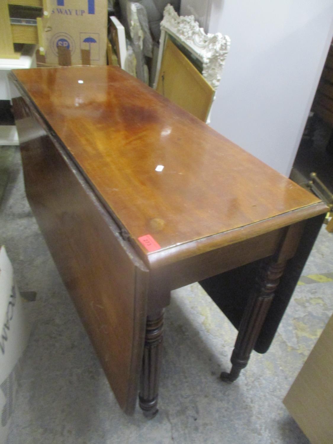 A Victorian mahogany fall flap table standing on turned and fluted legs, 69" h x 106"w