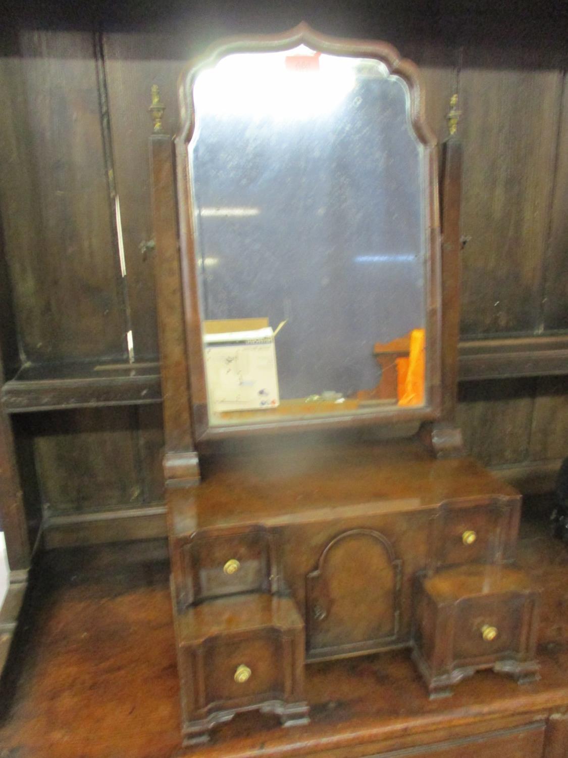 An early 20th century walnut dressing table mirror above four drawers flanking a central cupboard