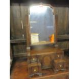An early 20th century walnut dressing table mirror above four drawers flanking a central cupboard