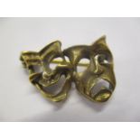 A yellow metal brooch fashioned as two masks