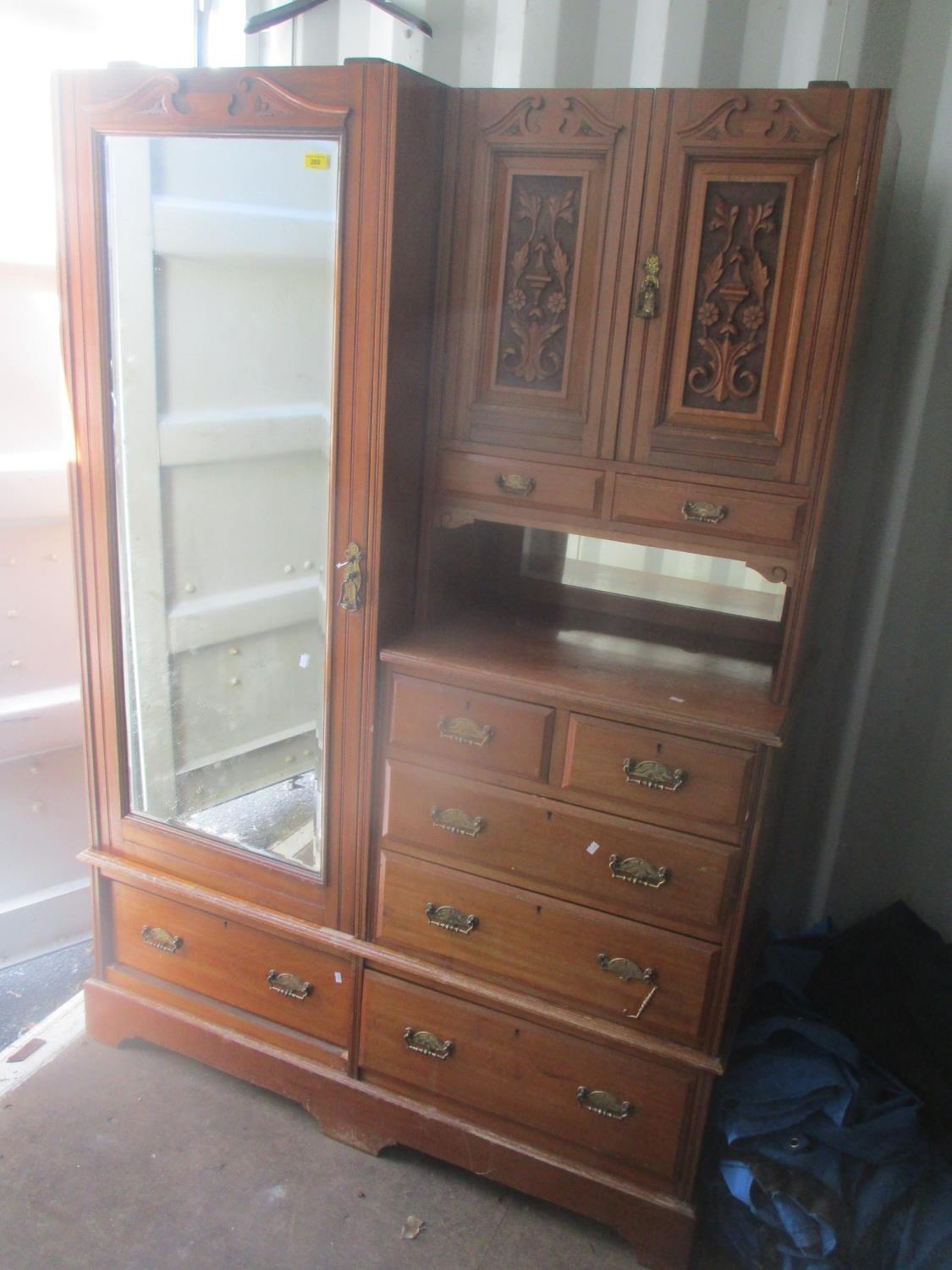 A late Victorian walnut wardrobe having a single mirrored door, two carved cupboard doors and