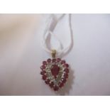 A gold, ruby and diamond heart shaped pendant, stamped 575, total weight 2.1g