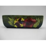 A Moorcroft Hibiscus pattern elongated trough decorated in purple, green and yellow, impressed
