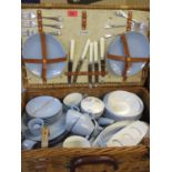 A vintage Coracle picnic basket and contents with additional metalware items and Thermos flasks
