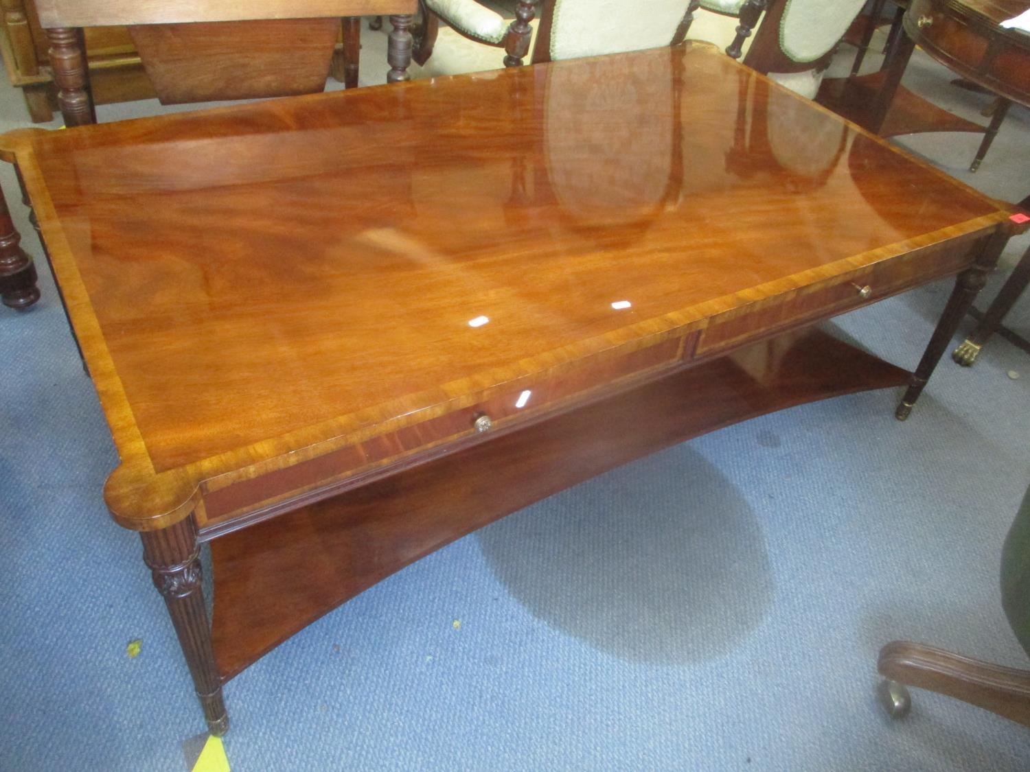 A large reproduction mahogany two tier coffee table having two inset drawers and fluted tapering